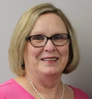 A woman with glasses and a pink shirt